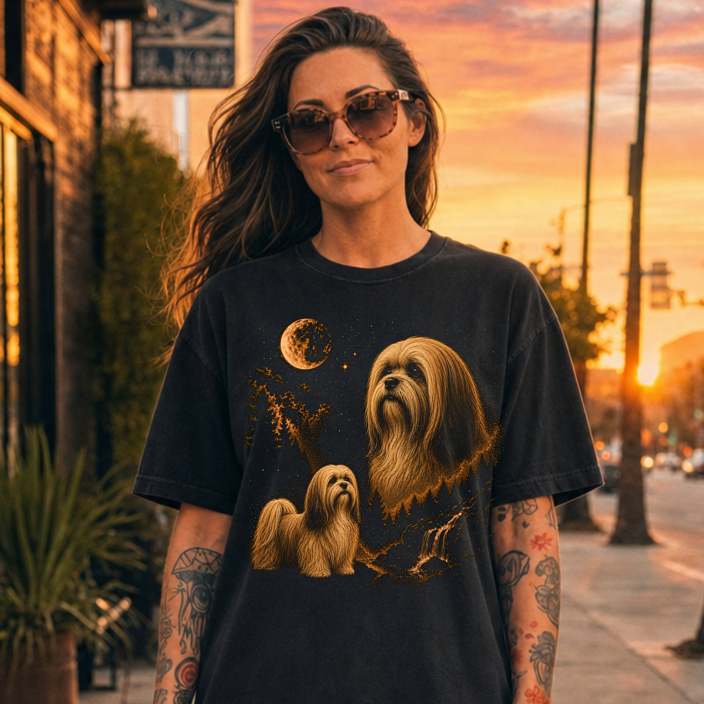 Woman wearing a black t-shirt with Lhasa Apso dog illustrations on a city street at sunset.