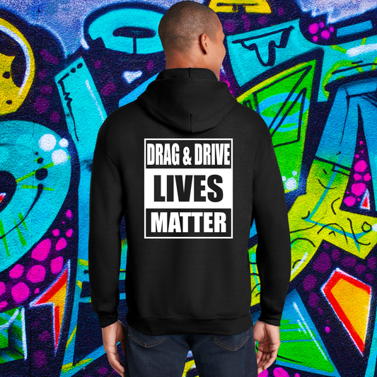 Person wearing a black hoodie with 'DRAG & DRIVE LIVES MATTER' text against a colorful graffiti background