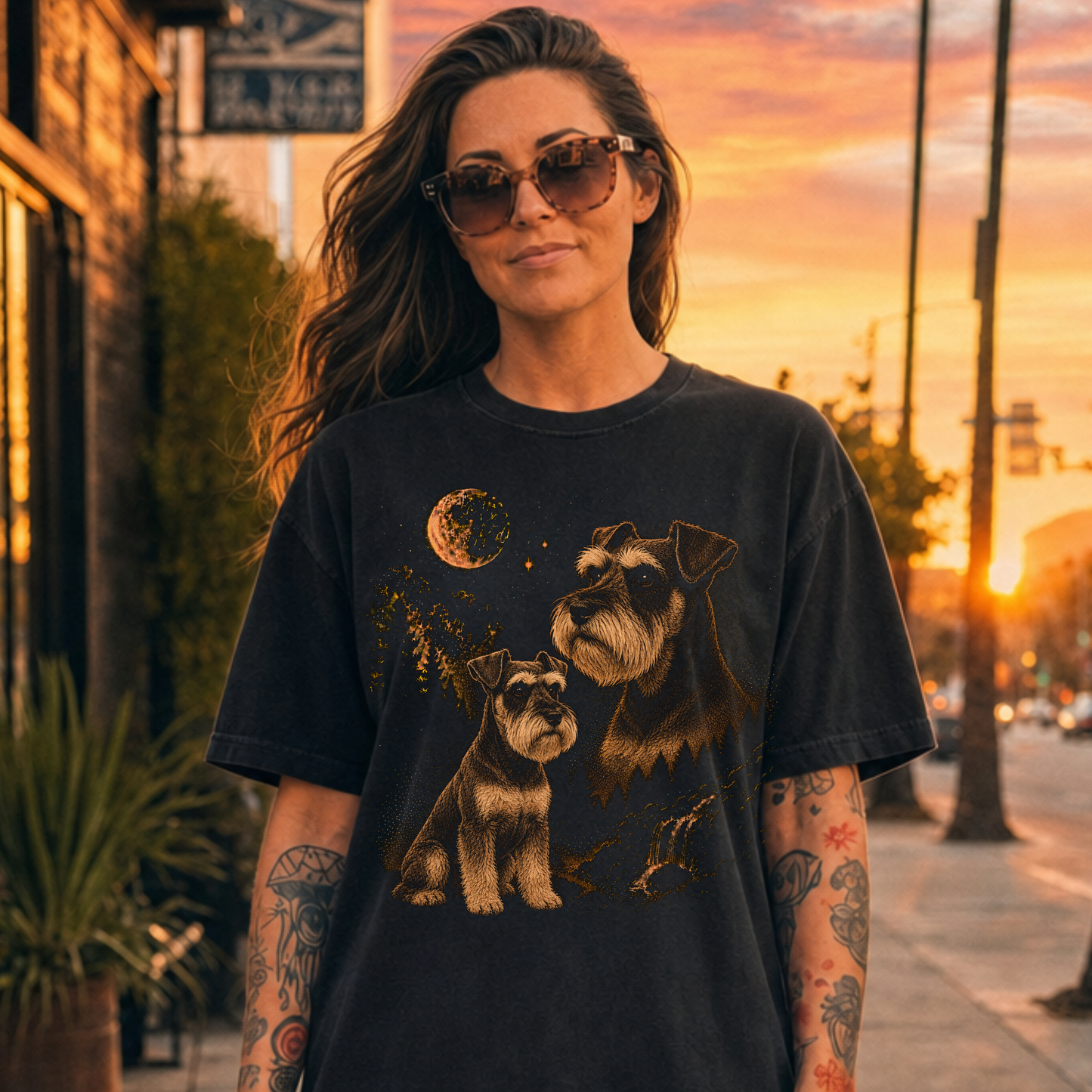 Woman wearing a black t-shirt with a  Schnauzer dog graphics against a sunset cityscape.